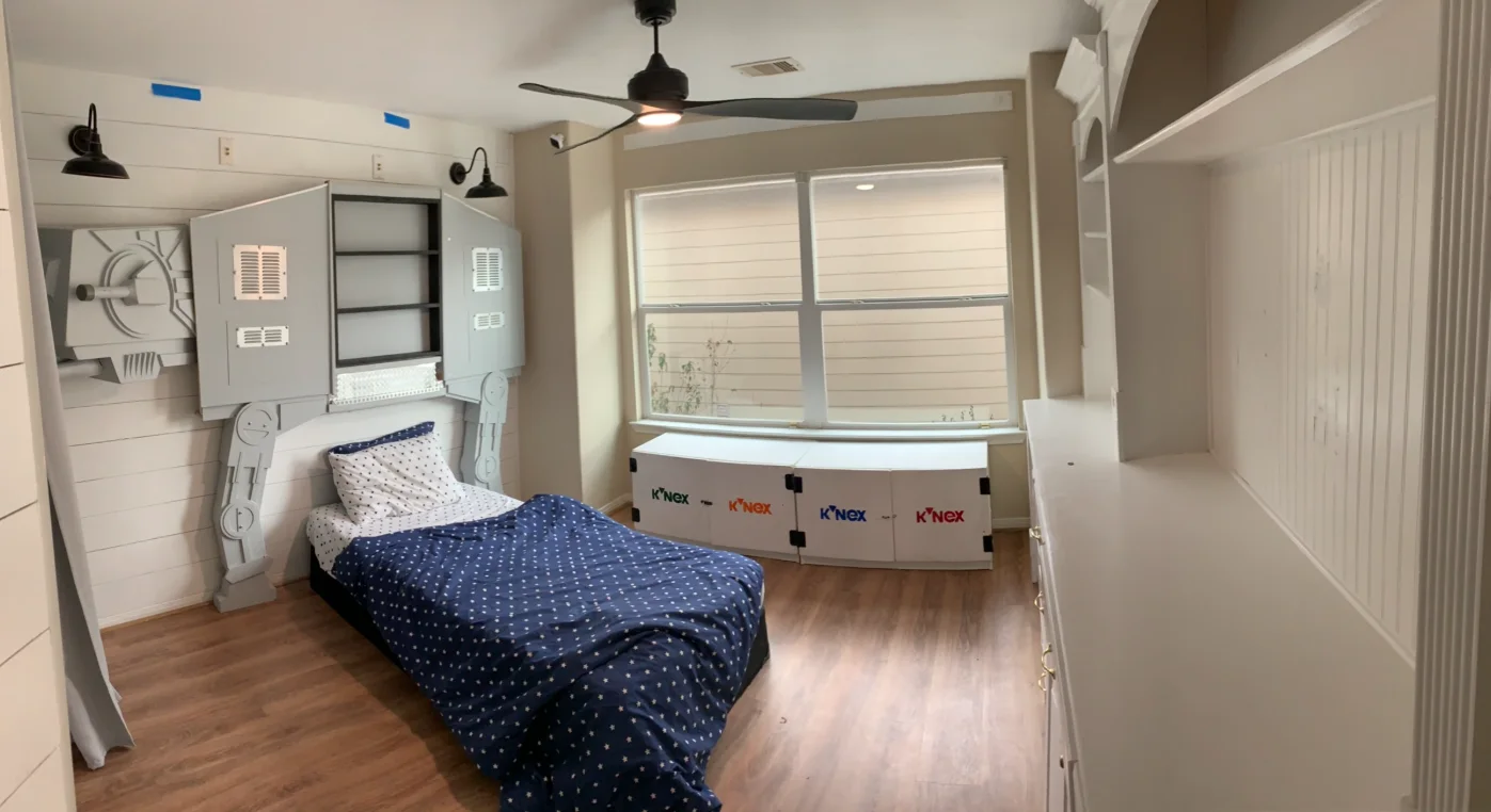 Shiplap bedroom with a Star Wars AT-AT model beside a built-in bed and drawers.